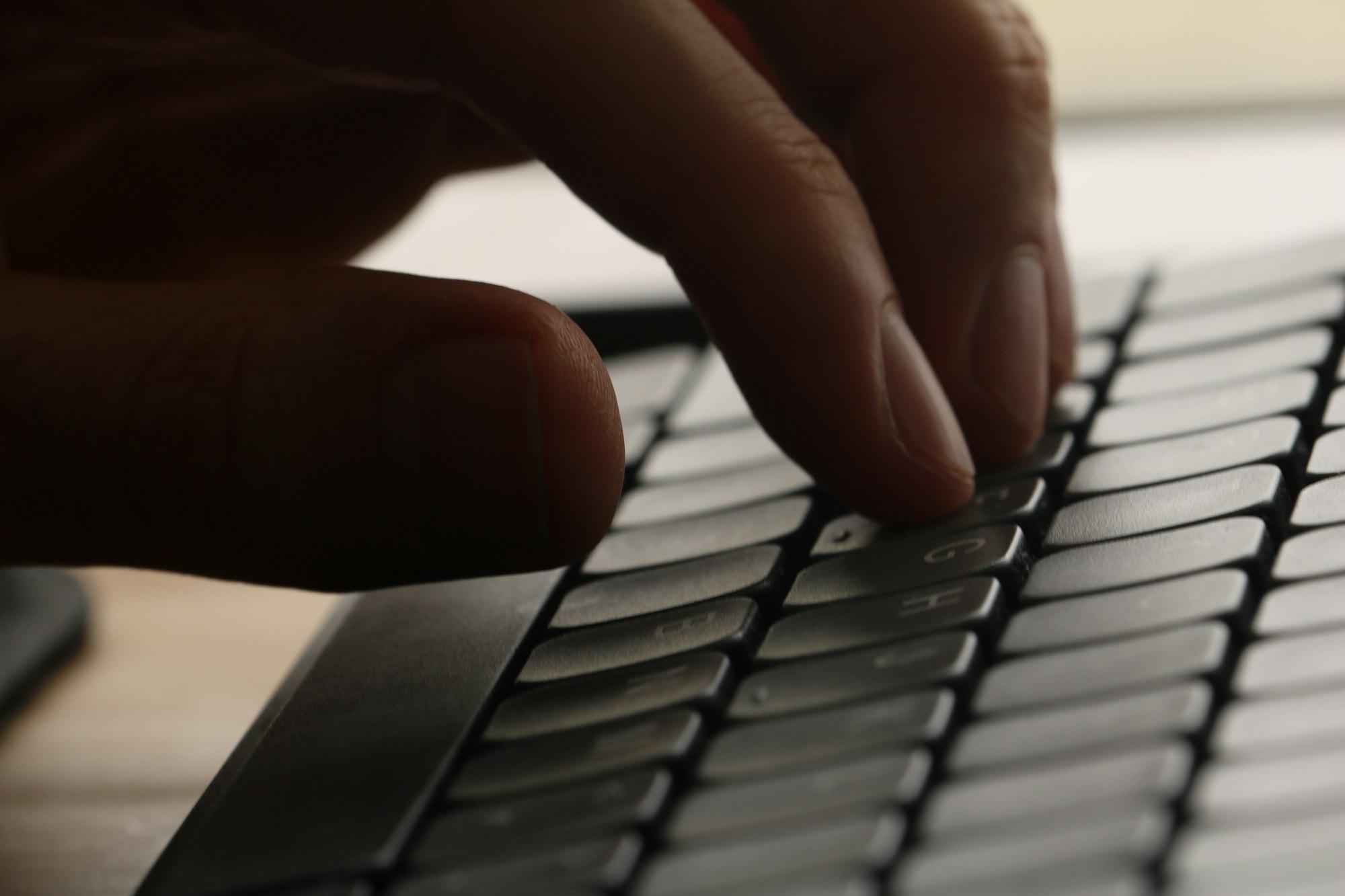 Close-up of hands working at a keyboard